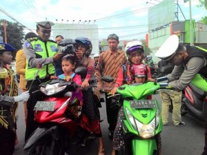 SATLANTAS MEMBERIKAN HELM KEPADA PENGENDARA MOTOR